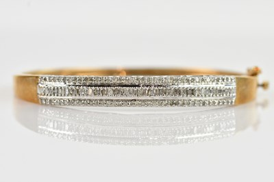 Lot 1133 - A yellow metal diamond set hinged snap bangle,...