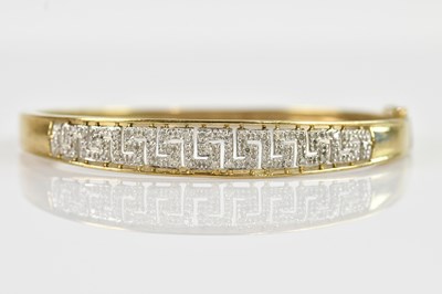 Lot 1183 - A yellow metal diamond set hinged bangle with...