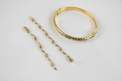 Lot 1216 - An Italian yellow metal hinged snap bangle,...