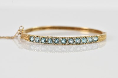 Lot 1192 - A 9ct yellow gold hinged snap bangle, set with...