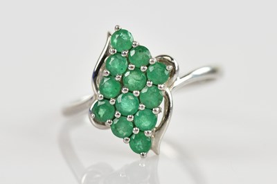 Lot 2405 - A platinum and emerald cocktail ring, set with...