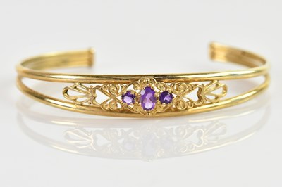 Lot 1218 - A 9ct yellow gold amethyst set snap bangle,...
