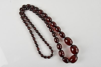 Lot 2172 - A cherry amber coloured beaded necklace,...
