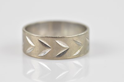 Lot 2358 - An 18ct white gold wedding band with engraved...