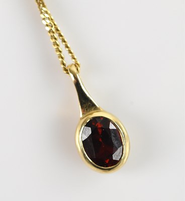 Lot 2167 - A 9ct yellow gold pendant, with central garnet...