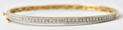Lot 1196 - A 9ct gold bangle half set with diamonds,...
