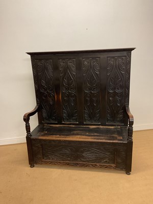 Lot 872 - A carved oak box settle, with storage under...