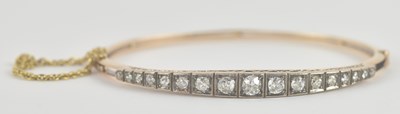 Lot 1444 - A gold diamond set hinged bracelet, the top...