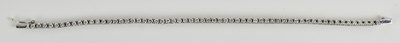 Lot 1445 - An 18ct white gold diamond set line bracelet,...