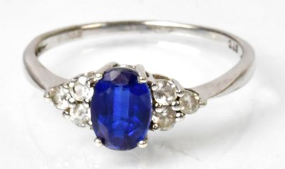 Lot 1166 - A 9ct yellow gold ring set with a central blue...
