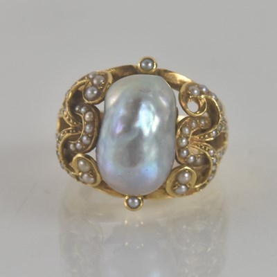 Lot 1294 - A yellow metal baroque pearl ring, the central...