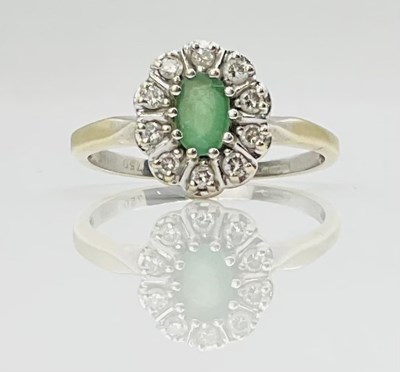 Lot 711 - An 18ct gold emerald and diamond oval floral...
