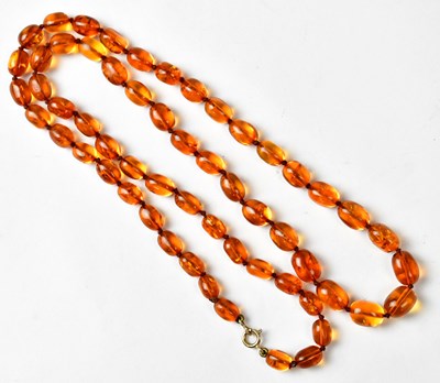 Lot 1280 - A string of slightly graduated amber beads,...