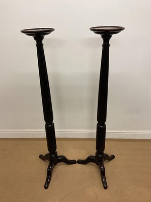Lot 880 - A pair of mahogany torchere columns on tripod...