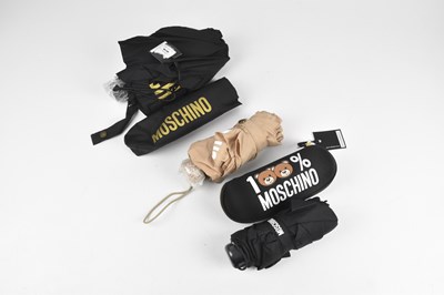 Lot 131 - MOSCHINO; two small umbrellas with black cases,...