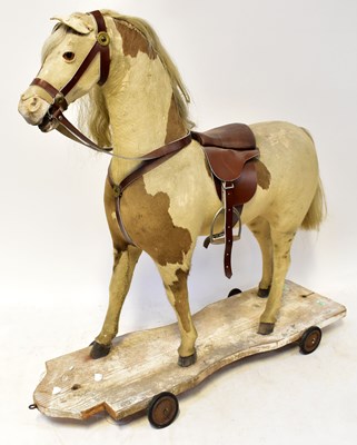 Lot 645 - A vintage pull-along horse with leather saddle,...