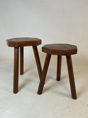 Lot 910 - Two hand carved three legged milking stools,...