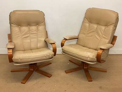 Lot 862 - A pair of leather swivel recliner armchairs...