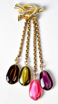 Lot 1220 - A base metal knot-shaped brooch suspending...