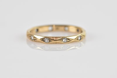 Lot 2512 - A yellow metal wedding band set with clear...