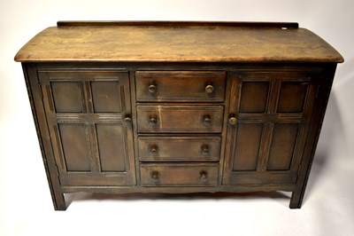 Lot 3 - An Ercol-style dark elm dresser base with a...