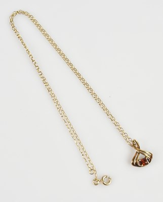 Lot 2221 - A 9ct yellow gold pendant set with a garnet...