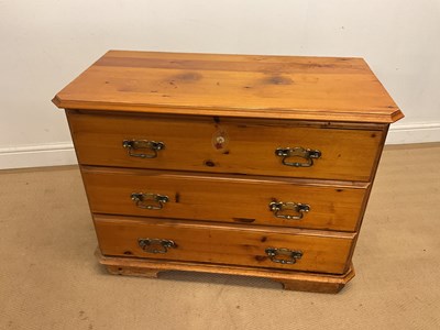Lot 912 - A varnished pine chest of three drawers,...