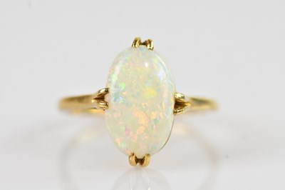 Lot 2341 - An 18ct yellow gold opal set dress ring, size...