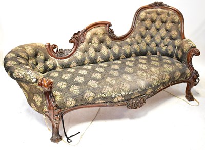 Lot 70 - A Victorian walnut carved chaise longue, with...