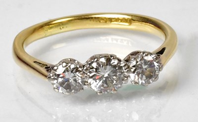 Lot 1135 - An 18ct gold and diamond set three-stone ring,...