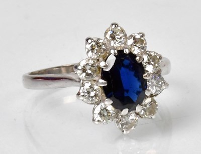 Lot 1139 - A diamond and sapphire cluster ring, the...
