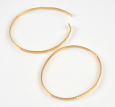 Lot 1175 - Two Iranian yellow metal bangles with chased...