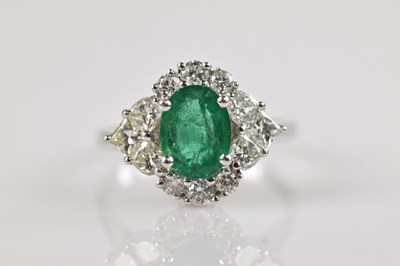 Lot 2272 - A white metal diamond and emerald cluster ring,...