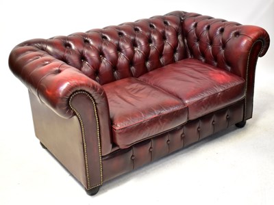 Lot 86 - A modern oxblood leather Chesterfield settee,...
