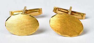 Lot 1315 - A pair of 18ct gold cufflinks of oval textured...