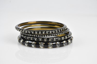 Lot 3 - CHANEL; a set of four gold tone bangles,...