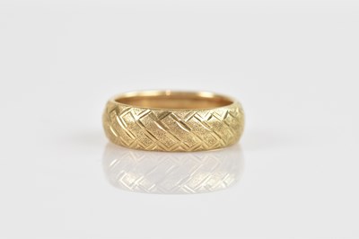 Lot 2596 - A yellow metal wedding band with chased...