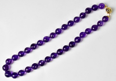 Lot 1286 - An amethyst chequerboard facet cut bead...