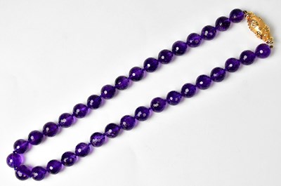 Lot 1287 - An amethyst chequerboard facet cut bead...