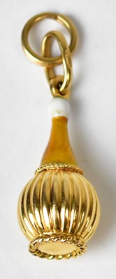 Lot 1239 - An 18ct gold charm in the form of a reeded...
