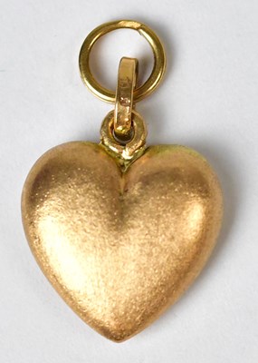 Lot 1241 - An 18ct gold charm in the form of a heart,...