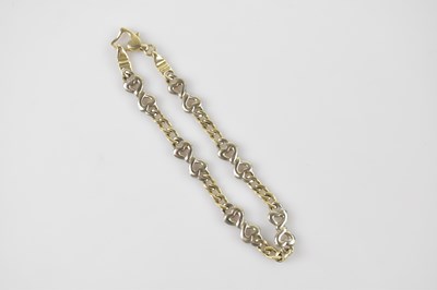 Lot 1156 - A yellow and white metal bracelet with heart...