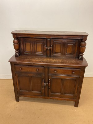 Lot 919 - ERCOL; a dark wood side cabinet, with a two...