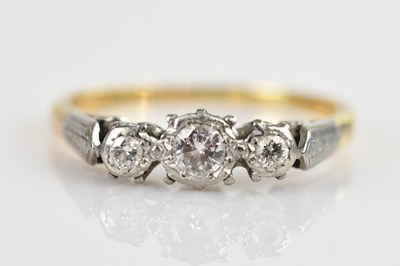 Lot 2442 - A yellow metal and diamond set three stone...