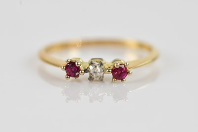 Lot 2445 - A yellow metal diamond and ruby three stone...