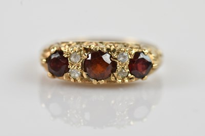 Lot 2448 - A 9ct yellow gold dress ring, set with garnets...