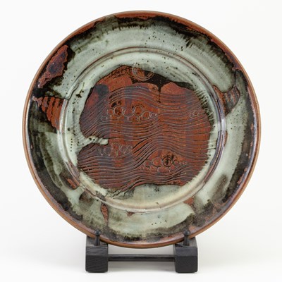 Lot 812 - A stoneware plate with incised landscape...