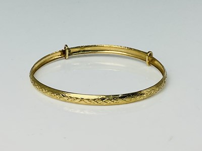 Lot 774 - A child's adjustable 9ct yellow gold bangle,...