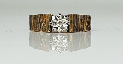 Lot 742 - A yellow metal ring with textured detail to...