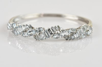 Lot 1229 - A white metal hinged snap bangle, stamped ‘9K’,...